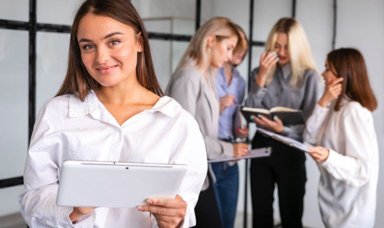 Equipo de asesoras trabajando en una oficina, una de ellas con una tablet